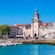 The old port in La Rochelle, France reveals a medieval retaining wall and an imposing clock tower